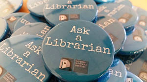 一堆藍色按鈕，上面有「Ask a Librarian」文字和歐洲大學學院標誌。 — 工作 壁紙