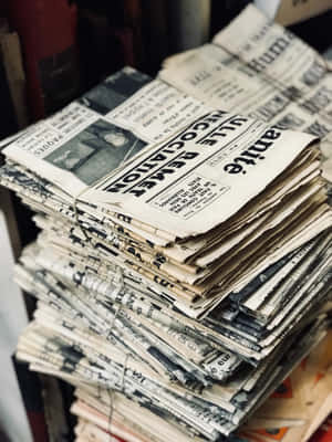 一堆帶有標題和磨損邊緣的舊法文報紙。 — Old Paper 壁紙
