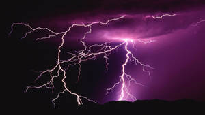 紫色閃電在暴風雨的夜空中，在黑暗的山脈上方劈啪作響。 — 閃電 壁紙