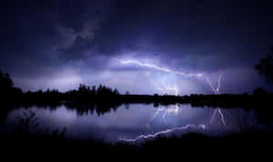 夜晚黑暗湖泊上空的閃電，帶有鮮明的倒影。 — 閃電 壁紙