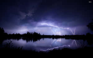 閃電擊中夜晚的黑暗湖泊，帶有鮮明的倒影。 — 閃電 壁紙
