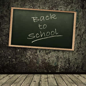 黑板上有「Back to School」，背景為有紋理的牆壁和木地板。 — 黑板 壁紙