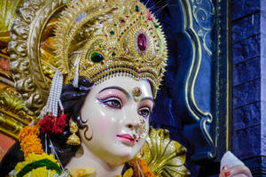 一尊詳細的印度教女神雕像，戴著鑲寶石的皇冠和花環。 — Maa Durga 壁紙