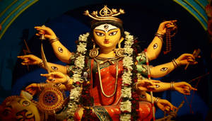 多臂印度教女神的彩色雕像，裝飾著鮮花和珠寶。 — Maa Durga 壁紙