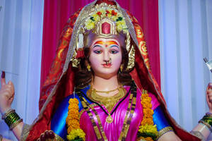 色彩繽紛的印度教女神雕像，佩戴金色珠寶和金盞花花環。 — Maa Durga 壁紙