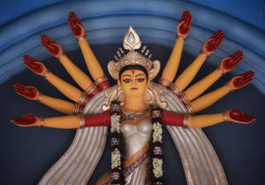 色彩繽紛的印度教女神杜爾迦雕像，有十隻手臂和花環。 — Maa Durga 壁紙