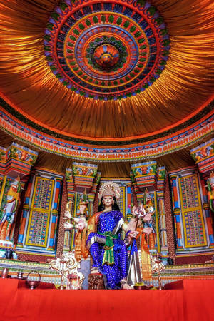 寺廟中色彩繽紛的神像，帶有精緻的天花板和紅色祭壇。 — 金廟 壁紙