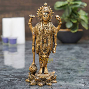 金色多臂印度教神像，帶有珠寶，立於大理石表面，附近有蠟燭和植物。 — 斯瓦米納拉揚 壁紙