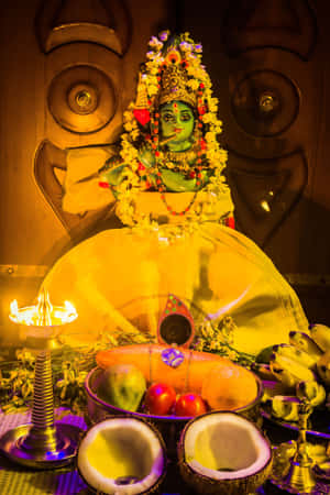 一尊印度教神像，配有水果、椰子和點燃的油燈等供品。 — Maa Durga 壁紙