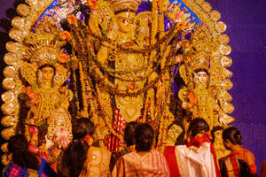 信徒們在夜間向金色杜爾加普迦神像鞠躬。 — Maa Durga 壁紙