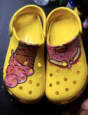 黃色Crocs鞋繪有冰淇淋和甜甜圈圖案。 — Crocs 壁紙