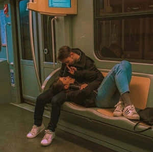 一對情侶在溫暖燈光的車廂內的地鐵長椅上親吻。 — 可愛情侶 壁紙