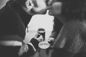 一對情侶在桌上拿著咖啡杯分享一個吻。 — 可愛的愛情 壁紙