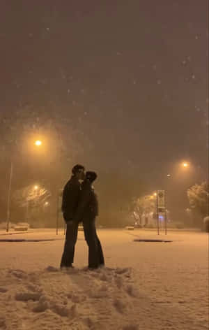 一對情侶在夜晚的路燈下，於飄雪中親吻。 — 晚安 壁紙