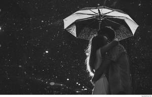 一對情侶在夜雨中於傘下親密擁抱。 — 情侶擁抱 壁紙