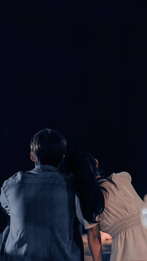 一對情侶緊密地站在一起仰望夜空。 — 車銀優 GIF 壁紙