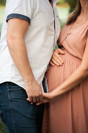 一個男人和一個孕婦在戶外溫馨的時刻手牽手。 — 懷孕 壁紙