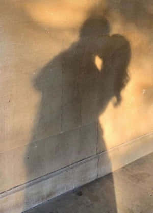 日落時分混凝土牆上情侶親吻的影子。 — 愛就是愛 壁紙
