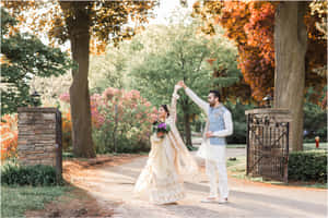 一對穿著傳統婚禮服飾的情侶在秋日公園中跳舞。 — 婚禮 壁紙