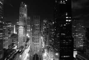 帶有明亮摩天大樓和教堂尖塔的夜景城市黑白照片。 — 紐約 壁紙