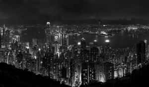 黑白夜景城市景觀，有燈火通明的摩天大樓和港灣。 — 城市風景 壁紙