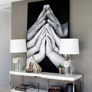 現代玄關桌配有燈飾和裝飾，下方是黑白祈禱之手藝術印刷品。 — 民間藝術 壁紙