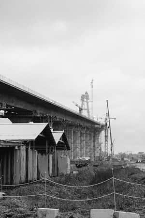 正在建造中的大橋，配有起重機和臨時圍欄 — 復古 壁紙