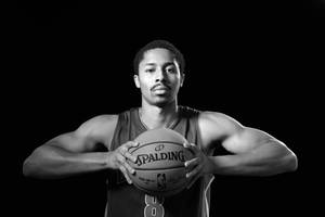 一位身穿球衣的籃球運動員在攝影棚中手持 Spalding 籃球。 — 克里夫蘭騎士隊 壁紙