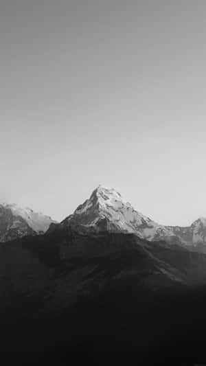 一座積雪的山峰，黑白配色，背景為漸層天空。 — iPhone 11 Pro 壁紙
