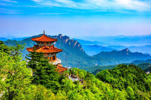 山上的寺廟，森林和遠處的山峰，藍天 — 廣州 壁紙
