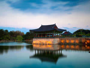 傳統韓國亭閣在黃昏時亮起，水面倒影完美 — 東京喰種風格 壁紙
