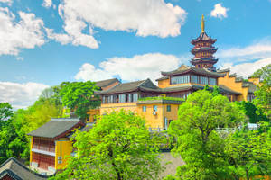 藍天白雲下，綠樹環繞的黃色寶塔和寺廟。 — 唐人街 壁紙