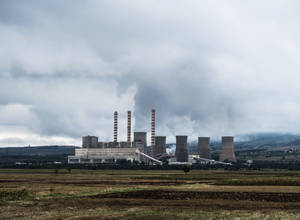 工業發電廠煙囪在陰天下的開闊田野上方排放煙霧。 — 能量 壁紙