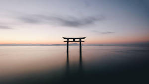 黃昏水面上的鳥居，平靜倒影與柔和天空色彩。 — 雅虎 壁紙