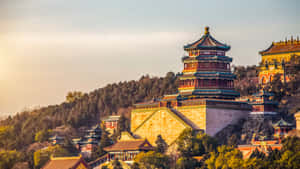 日落時分山坡上的古老中式寶塔，被樹木環繞 — 丘陵景觀 壁紙