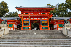 鮮豔的橙色日本神社，有石階和守護獅子雕像。 — 東京喰種風格 壁紙