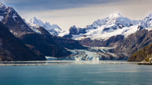 冰川流入平靜的峽灣，以白雪覆蓋的山脈為框。 — 山景 壁紙