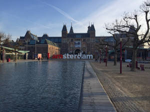 阿姆斯特丹博物館，帶有「I amsterdam」標誌和反射池，日落時分。 — 博物館 壁紙