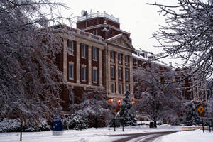 被雪覆蓋的大學建築，帶有霜凍的樹木和一條寧靜的小路。 — 醫療 壁紙