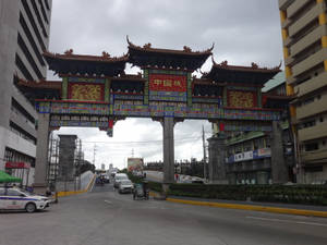 城市中的中式牌坊，有交通和建築物 — 唐人街 壁紙