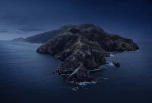 在繁星點點的夜空下，海洋中的岩石島嶼和拍打的海浪。 — MacBook Pro 美學 壁紙