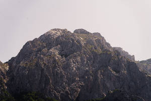 崎嶇的山峰，參差不齊的懸崖和稀疏的綠植，在蒼白的天空下。 — 克羅埃西亞 壁紙
