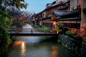 黃昏時分運河上的木橋，傳統日本房屋和秋葉。 — 日本 壁紙