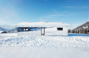 藍天下，雪山山谷中一座被白雪覆蓋的鏡面小屋。 — 冬季房屋 壁紙