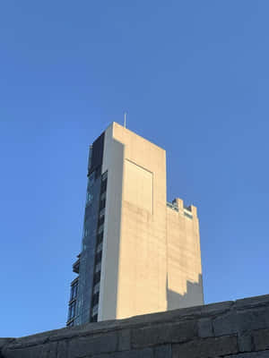 明亮的藍天下，擁有混凝土和玻璃外牆的高層現代建築 — 城市 壁紙