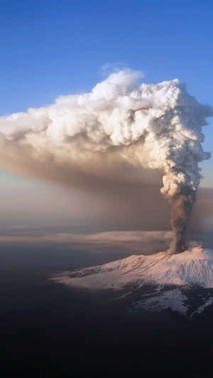 一座白雪覆蓋的火山噴發，巨大的火山灰雲升上天空。 — 煙動圖 壁紙