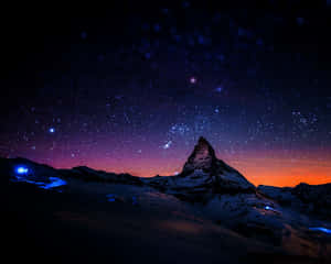 在帶有紫色和橙色色調的星空暮色天空下的積雪山峰。 — 太空 壁紙