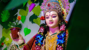 色彩繽紛的印度教女神雕像，捧著一盆萬壽菊。 — Maa Durga 壁紙