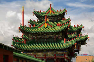 在多雲的天空下，一座色彩鮮豔的綠紅傳統中式寺廟，屋頂細節華麗。 — 城堡動畫 壁紙