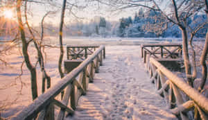 雪覆蓋的木橋，結冰的河流，金色日出 — 冬季美學 壁紙